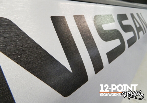 A close-up of the 3M 1080 Brushed Aluminum texture with the digital print. 12-Point SignWorks