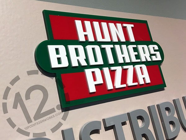 A close-up of the Hunt Brothers Pizza dimensional logo in their red, green and white brand colors. Custom Signage by 12-Point SignWorks - Franklin TN