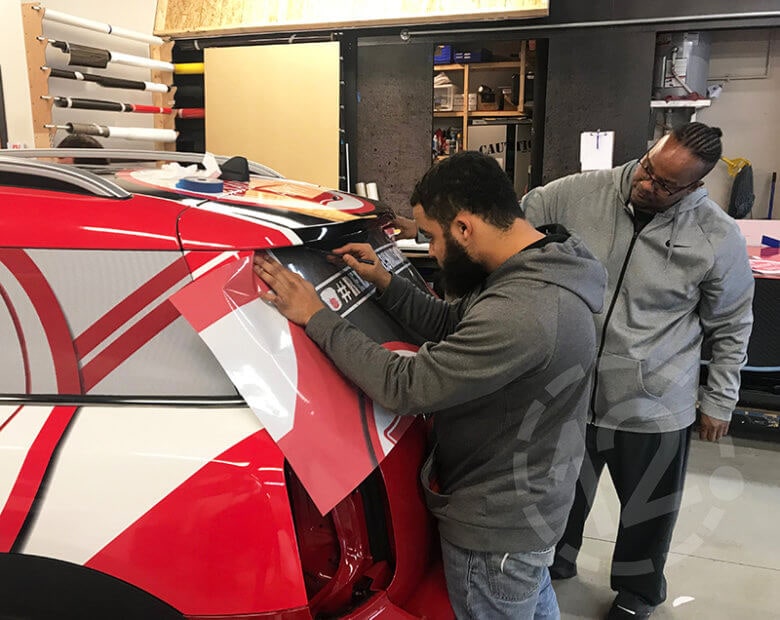 Installing perforated vinyl on a Vehicle Wrap for the Salvation Army of Nashville by 12-Point SignWorks. 