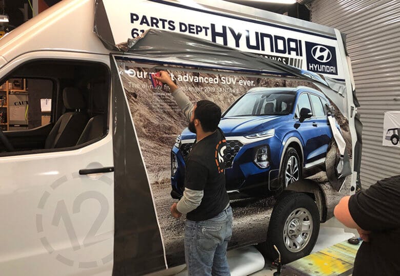 Installation of a custom van wrap for Hyundai of Cool Springs by 12-Point SignWorks in Franklin, TN.