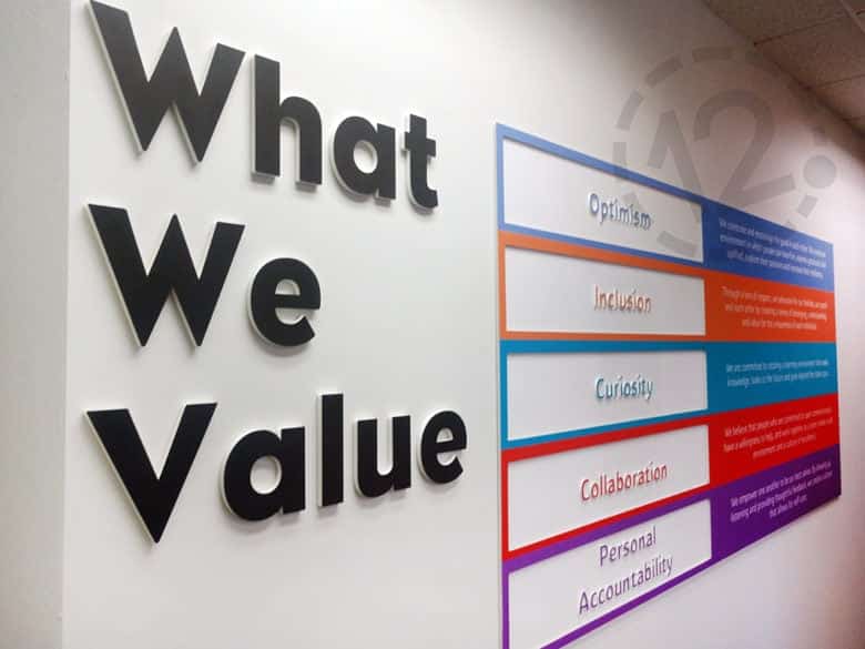 Custom values display for Monroe Harding fabricated and installed by 12-Point SignWorks.