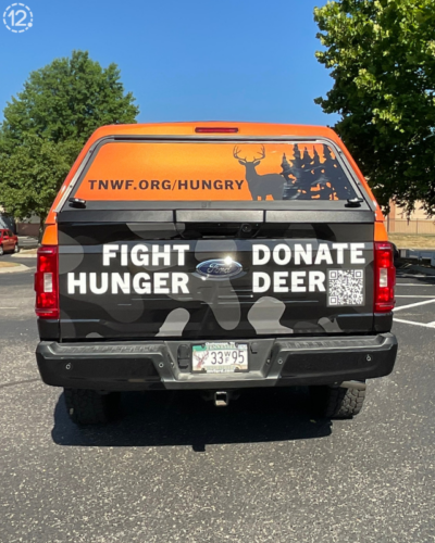 rear tailgate of custom truck wrap that says fight hunger donate deer